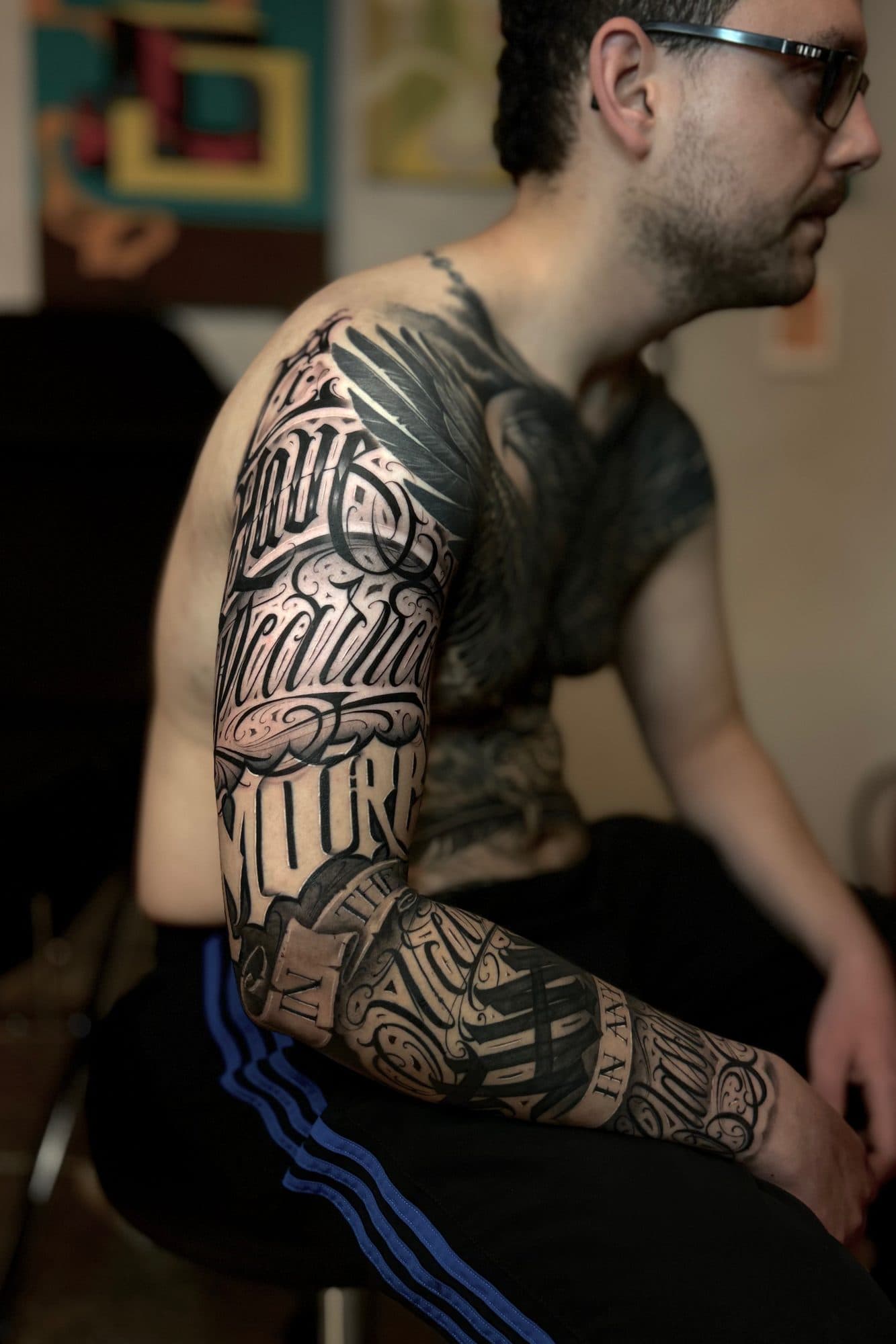 Manga e peito em lettering, num homem sentado de perfil